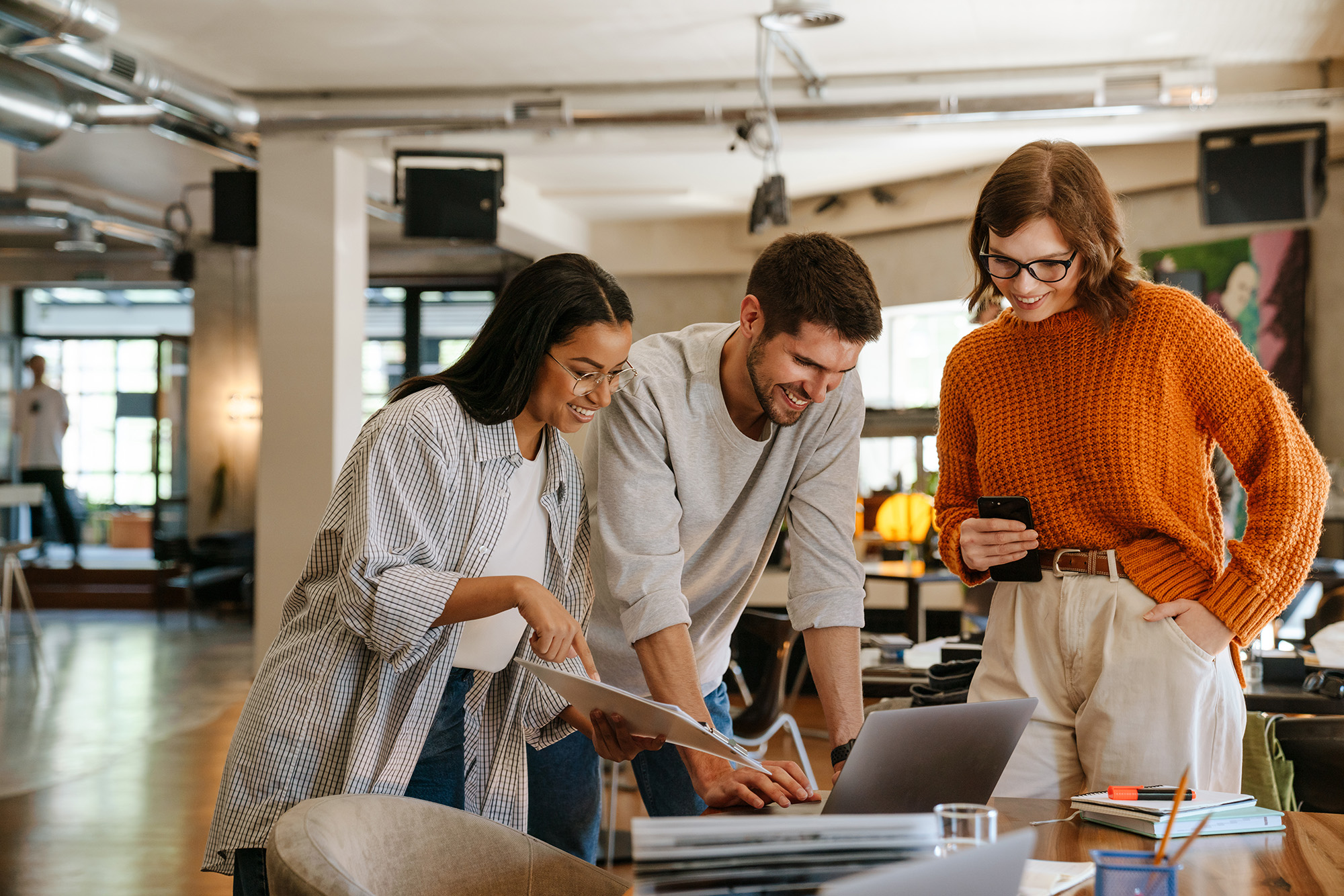 Woman sitting in a loft working from her laptop