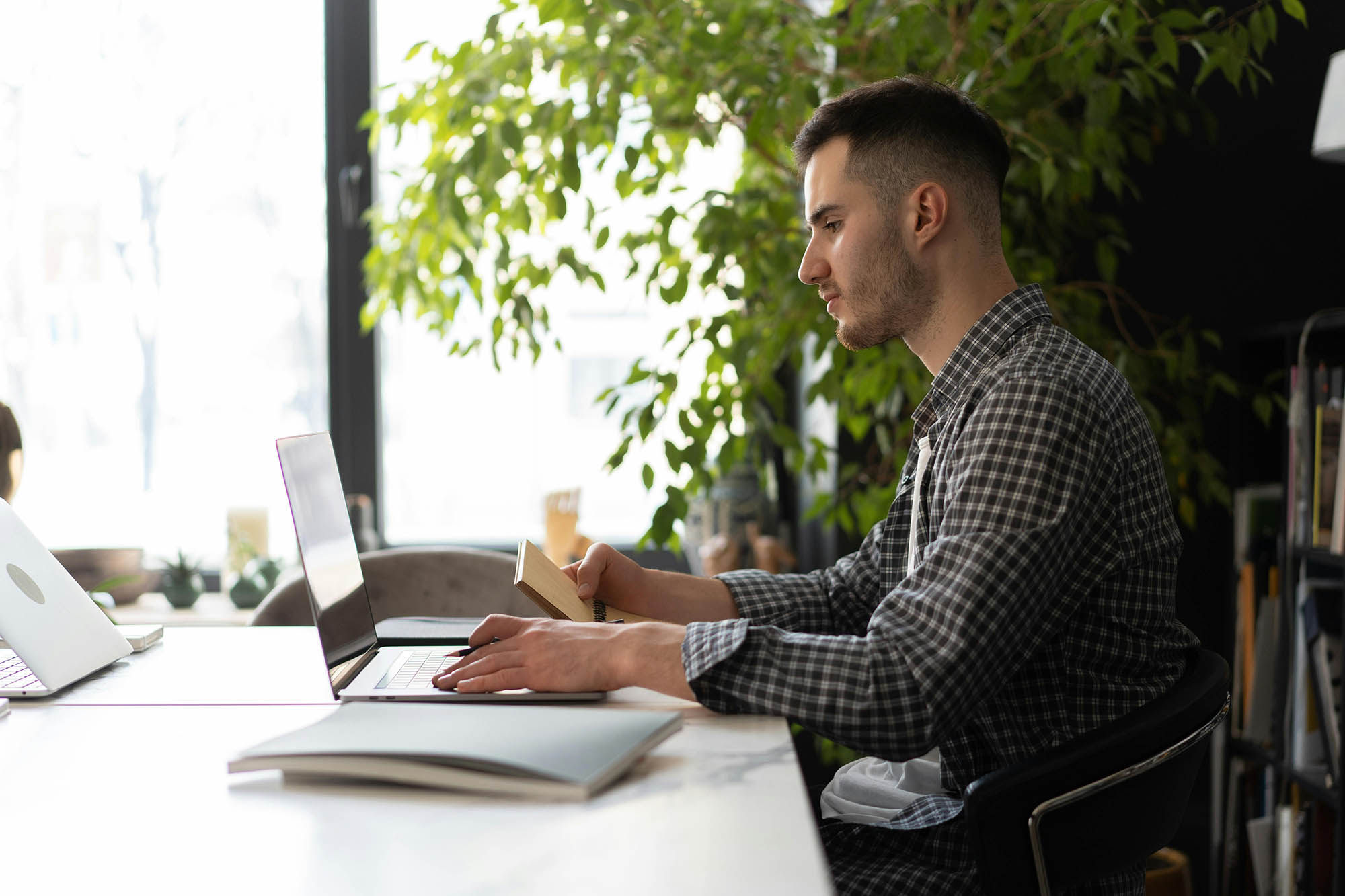 CFO reviewing journal entry accounting tasks on laptop while taking notes