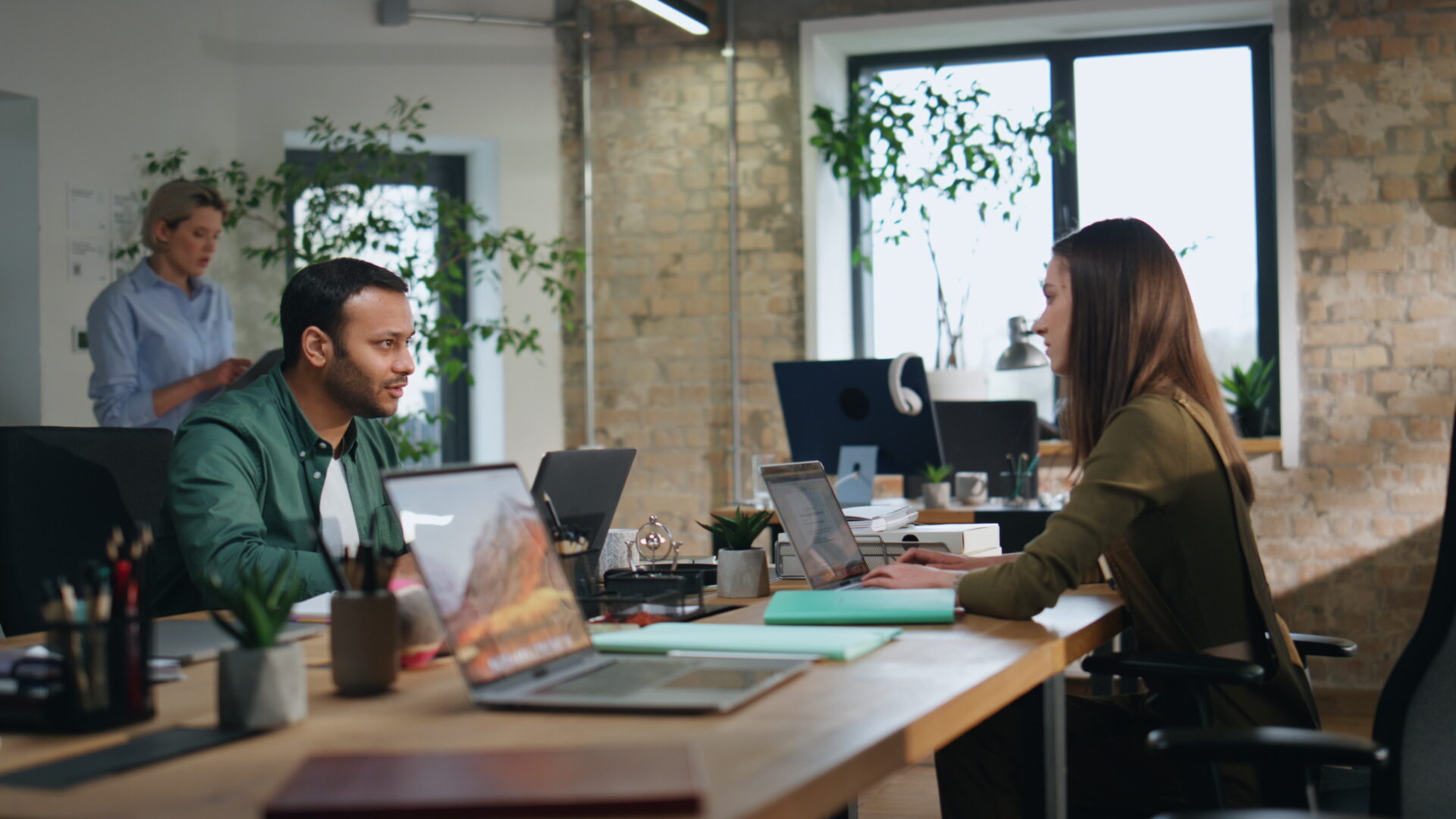 Team discussing AI-driven solutions for financial close processes in a modern office setting, with laptops, collaborative workspace, and natural lighting.