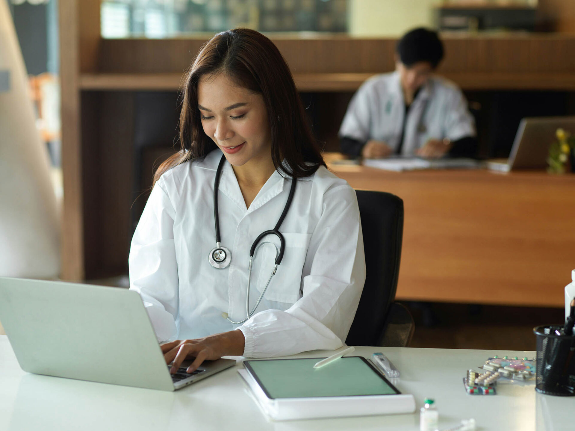Healthcare professional reviewing account reconciliation tasks on laptop in medical office
